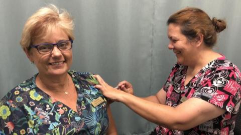 Innisfail Family Health Assistant Practice Manager – Annette Ah Shay (left) receives her COVID-19 vaccine from Registered Nurse Michelle McCarthy.jpg