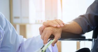 Doctor holding elderly patients hand