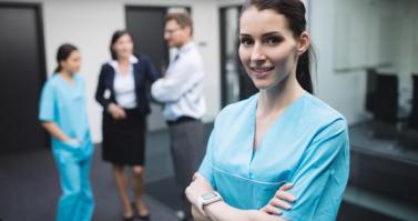 Smiling nurse standing with arms crossed