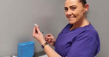 Nurse prepares needle with vaccine