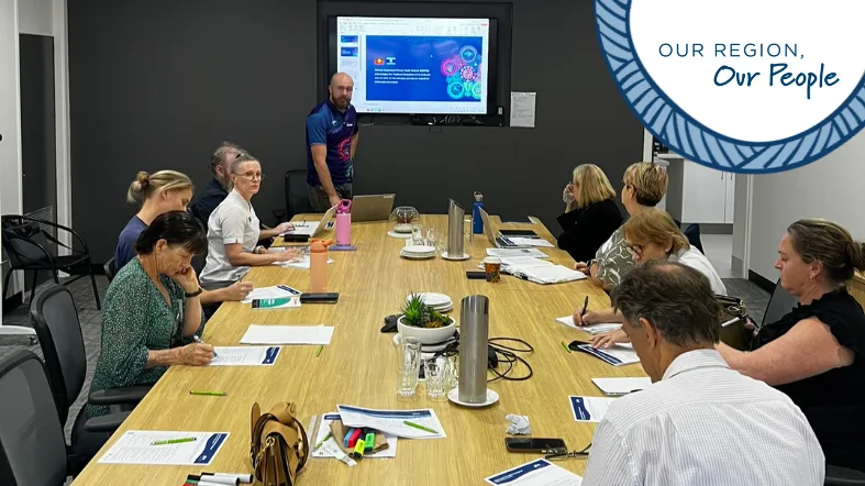 Group of people sitting around a table learning from a facilitator